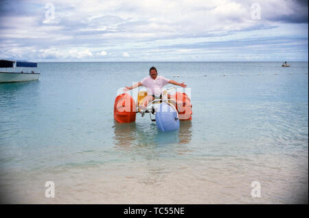 Der deutsche Sänger Klaus Baumgart posiert mit einem Dreirad vermutlich Tretboot am Strand auf den Bahamas, Ca. 1970er. Der deutsche Sänger Klaus Baumgart Posen mit einem Dreirad Tretboot am Strand wahrscheinlich auf die Bahamas, um 1970 n. Stockfoto