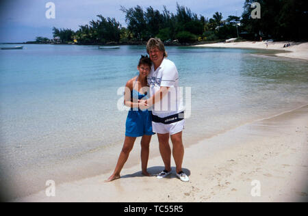 Der Sänger Klaus Baumgart posiert im Urlaub vermutlich auf den Bahamas am Strand mit seiner Ehefrau Ilona Schulz-Baumgart, Ca. 1970er. Der Sänger Klaus Baumgart stellt wahrscheinlich im Urlaub auf den Bahamas am Strand mit seiner Frau Ilona Schulz-Baumgart, um 1970 n. Stockfoto