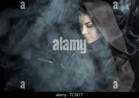 Frau in den Tod Kostüm holding Zwischenablage auf Schwarz Stockfoto