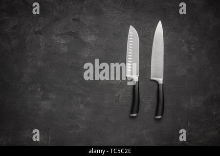 Koch und Santoku Messer auf dunklem Hintergrund Stockfoto