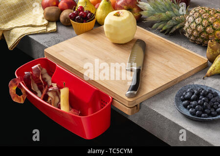Holz Schneidebrett mit Behälter, Santoku Kochmesser und frisches Obst. Gesunde Ernährung Konzept. Stockfoto
