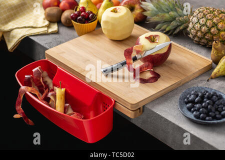 Holz Schneidebrett mit Behälter, Santoku Kochmesser und frisches Obst. Gesunde Ernährung Konzept. Stockfoto