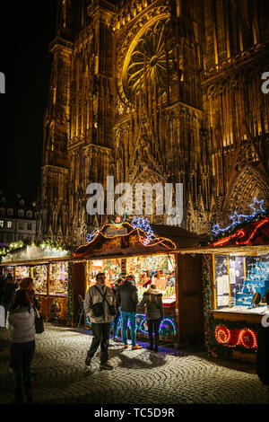 Straßburg, Frankreich - 29.November 2017: Kunden bewundern die Spielzeug, Souvenirs und Spielwaren in zentralen Chalet des Straßburger Weihnachtsmarkt mit Kathedrale Notre-Dame im Hintergrund Joyeux Noel Stockfoto