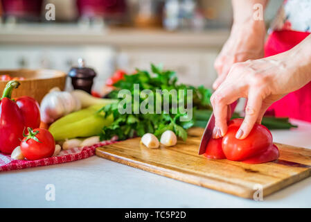 Weibliche hand mit Messer schneidet Bell Pfeffer in der Küche. Kochen Gemüse Stockfoto
