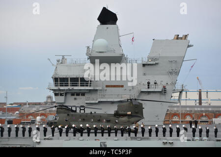 Mitgliedern der Besatzung stand auf dem Deck der HMS Queen Elizabeth, wie sie jubeln aus Veteranen an Bord der MV Boudicca Segel aus Portsmouth Harbour für die er Hafen von Le Havre in Frankreich im Rahmen der Gedenkfeiern zum 75. Jahrestag der D-Day Landungen. Stockfoto