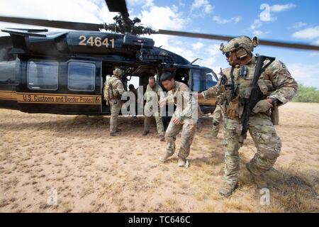 Us Border Patrol patrouillieren in einem Blackhawk Hubschrauber erkannt, dass eine Gruppe von illegalen Migranten, nachdem sie aus Mexiko auf der Tohono O'odham Indian Reservation 22. Mai 2019 in der Nähe von Pisinemo, Arizona durchquert. Die Gesichter sind verdeckt durch die Border Patrol, um ihre Identität zu schützen. Stockfoto