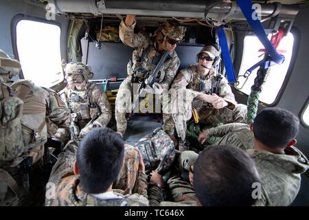 Us Border Patrol an Bord eines Blackhawk Helikopter Transport eine Gruppe von illegalen Migranten, nachdem sie aus Mexiko gekreuzt auf der Tohono O'odham Indian Reservation 22. Mai 2019 in der Nähe von Pisinemo, Arizona. Die Gesichter sind verdeckt durch die Border Patrol, um ihre Identität zu schützen. Stockfoto