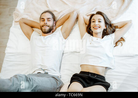 Portrait einer jungen und freundlichen Paar auf dem Bett liegend, Ansicht von oben Stockfoto