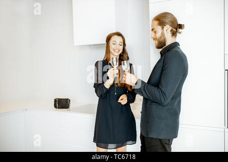 Der Mann und die Frau in Schwarz formelle Kleidung in inoffiziellen Treffen mit Getränken in der Küche zu Hause. Stockfoto