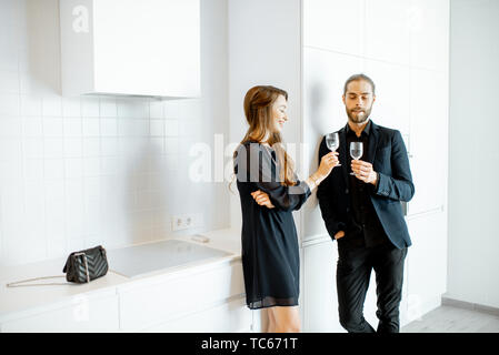 Der Mann und die Frau in Schwarz formelle Kleidung in inoffiziellen Treffen mit Getränken in der Küche zu Hause. Stockfoto