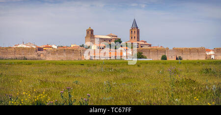 Blick über die Felder, um Reste der Mauern der Madrigal de las Altas Torres, Provinz Avila, Kastilien und Leon, Spanien. Die Kirche auf der linken Seite ist San Stockfoto