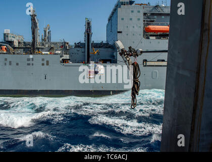 190531-N-SS 350-0085 Arabische Meer (31. Mai 2019) Der Dry Cargo und Munition ship USNS Cesar Chavez (T-AKE 14) sendet speichert in der Arleigh-burke-Klasse geführte Anti-raketen-Zerstörer USS Bainbridge (DDG96) während einer Auffüllung-auf-See. Bainbridge ist in die USA 5 Flotte Bereichen Maßnahmen zur Unterstützung der Marine im Einsatz für die Stabilität und Sicherheit in der Region zu gewährleisten und verbindet das Mittelmeer und den Pazifischen Raum durch den Westlichen Indischen Ozean und drei strategischen Punkten ersticken. (U.S. Marine Foto von Mass Communication Specialist 3. Klasse Jason Waite/Freigegeben) Stockfoto