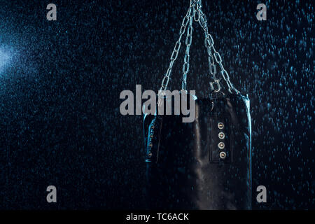 Leder Boxsack aufhängen auf Stahl ketten Wassertropfen auf Schwarz Stockfoto