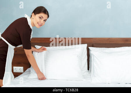 Junge Maid, Bett im Hotelzimmer Stockfoto