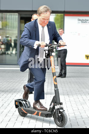 05. Juni 2019, Nordrhein-Westfalen, Dortmund: Armin Laschet (CDU), Ministerpräsident von Nordrhein-Westfalen, prüft eine e-Tretroller nach der Jahresversammlung der deutschen Vereinigung der Städte und Gemeinden. Rund 1300 Delegierte und Gäste treffen sich für die Hauptversammlung, die alle zwei Jahre stattfindet. Foto: Caroline Seidel/dpa Stockfoto