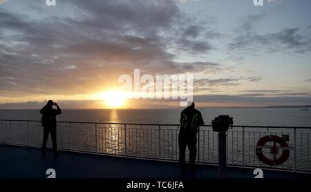 Collevillette, Frankreich. 06 Juni, 2019. 06 Juni 2019, France (Frankreich), Caen: Am frühen Morgen Passagiere beobachten Sie den Sonnenaufgang über den Englischen Kanal auf der Fähre von Portsmouth Caen. Dies ist der 75. Jahrestag der Landung der alliierten Truppen in der Normandie (D-Day). Foto: Kay Nietfeld/dpa Quelle: dpa Picture alliance/Alamy leben Nachrichten Stockfoto