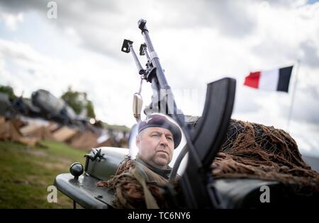 Merville, Frankreich. 06 Juni, 2019. Zum 75. Jahrestag der Landung der alliierten Truppen in der Normandie, ein Mann in Britischer Uniform kann auf der Rückseite gesehen werden Rückspiegel seiner historischen Militärfahrzeugen auf der Artillerie Batterie Website. Es erinnert an den 75. Jahrestag der Landung der alliierten Truppen in der Normandie. Foto: Kay Nietfeld/dpa Quelle: dpa Picture alliance/Alamy leben Nachrichten Stockfoto