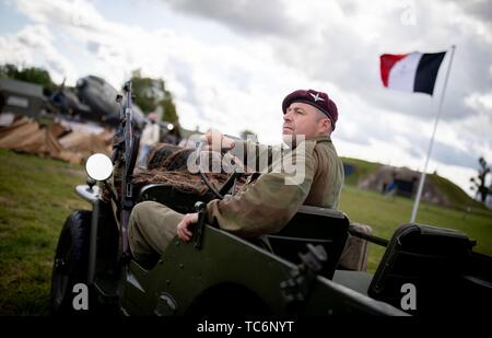 Merville, Frankreich. 06 Juni, 2019. Zum 75. Jahrestag der Landung der alliierten Truppen in der Normandie auf dem Gelände der Artillerie Batterie, einen Mann, in eine Britische uniform ist Klettern aus seinem historischen Militärfahrzeugen. Es erinnert an den 75. Jahrestag der Landung der alliierten Truppen in der Normandie. Foto: Kay Nietfeld/dpa Quelle: dpa Picture alliance/Alamy leben Nachrichten Stockfoto