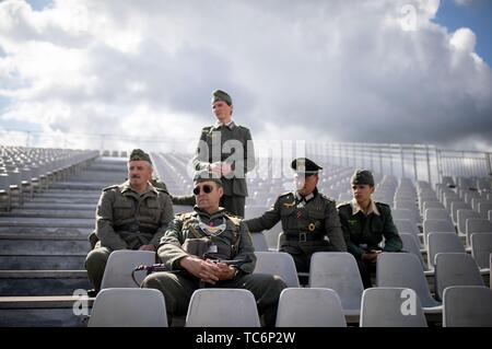 Merville, Frankreich. 06 Juni, 2019. Zum 75. Jahrestag der Landung der alliierten Truppen in der Normandie, Franzosen in deutschen Uniformen sitzen auf einer Tribüne auf dem Gelände der Artillerie Batterie. Die Region erinnert an den 75. Jahrestag der Landung der alliierten Truppen in der Normandie. Foto: Kay Nietfeld/dpa Quelle: dpa Picture alliance/Alamy leben Nachrichten Stockfoto