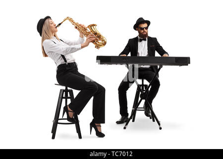 Volle Länge Schuß eines weiblichen Saxophonist und einen männlichen Keyboarder auf weißem Hintergrund Stockfoto