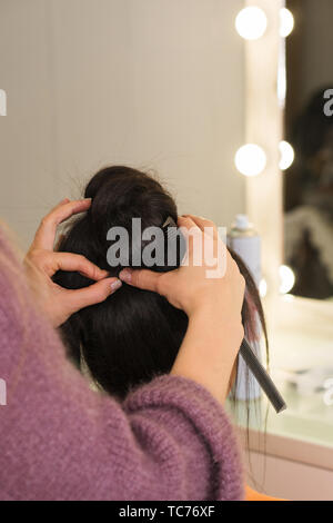 Hände von Friseur Form hoher Büschel von Haaren. Workshop obere bun Frisur zu erstellen. Ausbildung Konzept. Schönheit der Industrie. Platz für Text Stockfoto