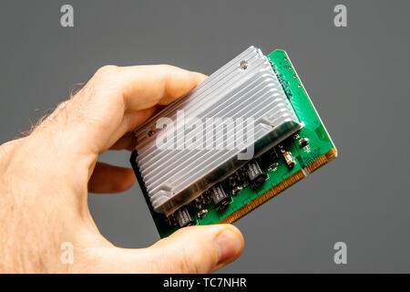 Paris, Frankreich - Apr 9, 2019: der Mensch hand mit grauem Hintergrund HP 407748-001, das Spannungsreglermodul für Proliant Server Stockfoto