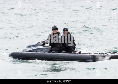 Zwei Britische Polizisten patrouillieren die Gewässer rund um Portsmouth auf einem Jet Ski, während Donald Trump Besuche für den D-Day 75 kom Stockfoto