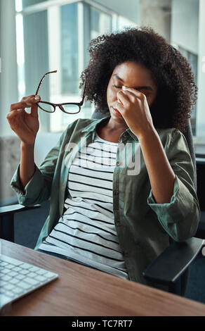 Betonte junge geschäftsfrau im Büro Stockfoto