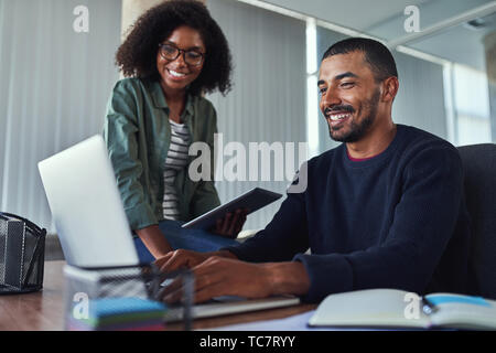 Lächelnde kreative Kollegen zusammen die Arbeit im Büro Stockfoto