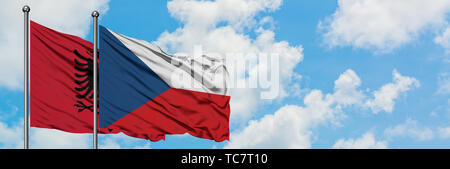 Albanien und Tschechien Flagge im Wind gegen Weiße bewölkt blauer Himmel zusammen. Diplomatie Konzept, internationale Beziehungen. Stockfoto