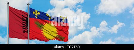 Albanien und Kroatien Flagge im Wind gegen Weiße bewölkt blauer Himmel zusammen. Diplomatie Konzept, internationale Beziehungen. Stockfoto