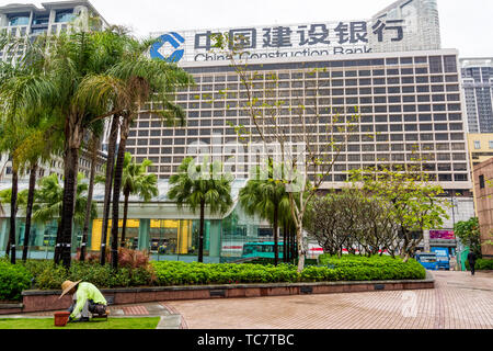 Hongkong, China, März 2013 Chinesische Gärtner bei der Arbeit, Pflege Rasen vor der China Construction Bank Stockfoto