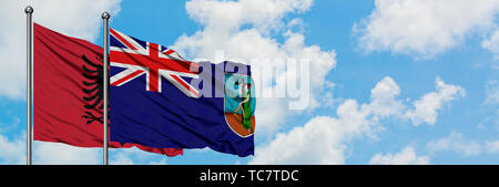 Albanien und Montserrat Flagge im Wind gegen Weiße bewölkt blauer Himmel zusammen. Diplomatie Konzept, internationale Beziehungen. Stockfoto