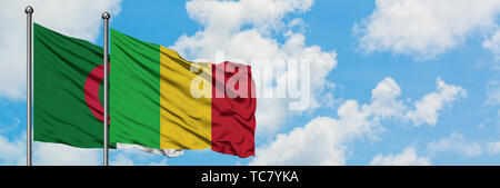 Algerien und Mali Fahne im Wind gegen Weiße bewölkt blauer Himmel zusammen. Diplomatie Konzept, internationale Beziehungen. Stockfoto