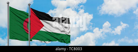 Algerien und Palästina Flagge im Wind gegen Weiße bewölkt blauer Himmel zusammen. Diplomatie Konzept, internationale Beziehungen. Stockfoto