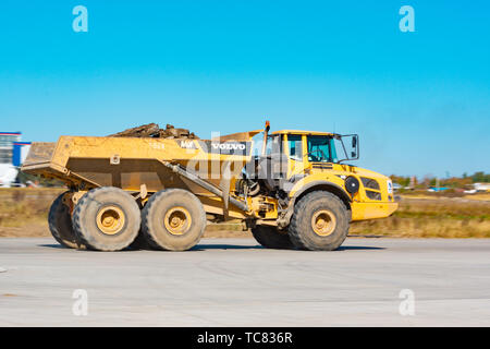 Die gelbe Sattelschlepper Volvo A40F am Flughafen in den Bau einer neuen Start- und Landebahn in Betrieb ist. Stockfoto