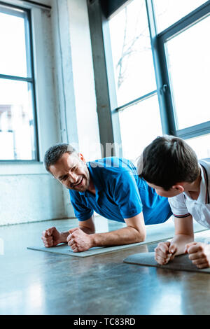 Vater und Sohn tun plank Übung auf Fitness Matten an Gym Stockfoto