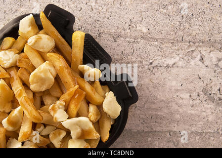 Poutine in einem takeout Container. Mit Pommes frites, Soße und Quark zubereitet. Kanadische Küche. Stockfoto