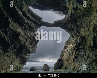 Der Blick aus dem Inneren der Höhle bei Myrdalshreppur in Island zum Meer Stockfoto