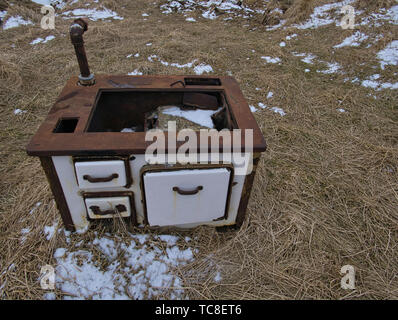 Ein alter Holzofen wurde in der offenen auf einer Wiese geparkt Stockfoto