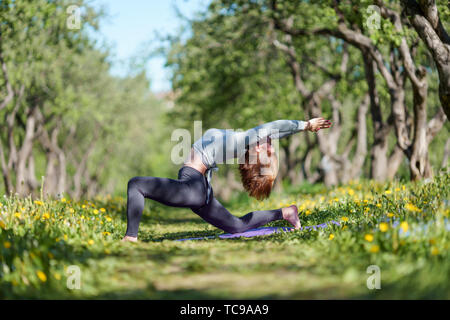 Foto von Mädchen mit erhobenen Armen Yoga im Wald bei Tag Stockfoto