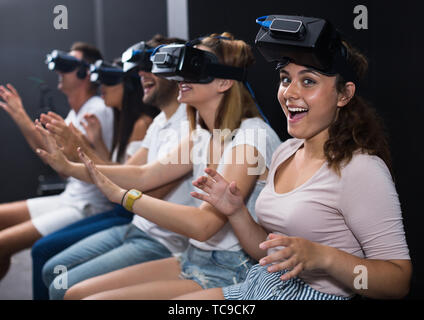 Junge Frau schaut zu spannenden Film mit Freunden im VR-Brille in der Unterhaltung. Stockfoto