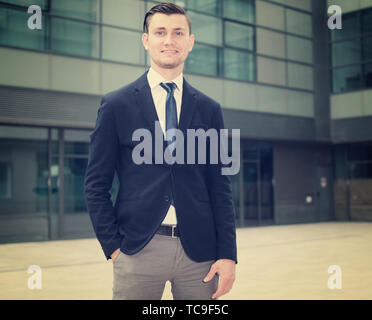 Portrait von Geschäftsmann in Anzug, steht in der Nähe des Büros. Stockfoto
