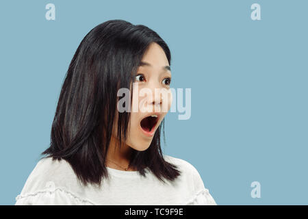 Koreanische junge Frau Brustbild auf Blau studio Hintergrund. Weibliche Modell im weißen Hemd. Immer erstaunt, schockiert und überrascht. Konzept der menschlichen Gefühle, Mimik. Vorderansicht. Stockfoto
