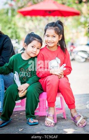 Zwei hübsche kleine kambodische Mädchen hängen zusammen in der Nähe Des Königlichen Palastes in Phnom Penh, Kambodscha. Stockfoto