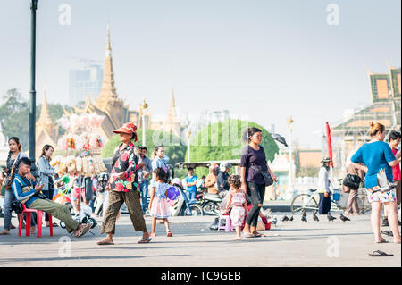 Familien genießen einen Tag mit Tauben, kaufen Spielzeug und Ballons und gehen entlang der Promenade in der Nähe des Königlichen Palastes Phnom Penh Kambodscha. Stockfoto