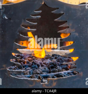 Platz in der Nähe eines Black Metal Feuerstelle mit einer Öffnung in der Form eines Baumes Stockfoto