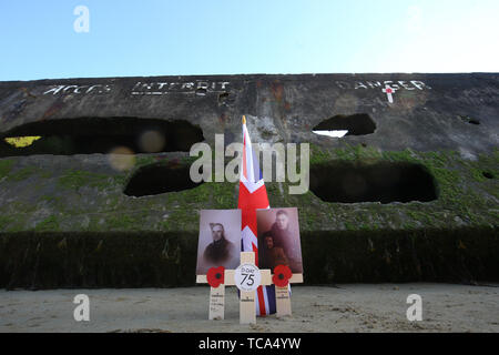 Memorial Kreuze, Fotografien und eine Union Flag durch die Mulberry Hafen von Arromanches in der Normandie, Nordfrankreich, vor einem Tag der Veranstaltungen den 75. Jahrestag des D-Day zu markieren. Stockfoto