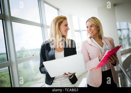 Lächelnd Geschäftsfrauen sprechen und gemeinsam im Büro Stockfoto