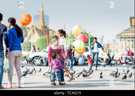 Familien genießen einen Tag mit Tauben, kaufen Spielzeug und Ballons und gehen entlang der Promenade vor dem Königspalast Phnom Penh Cambodi Stockfoto